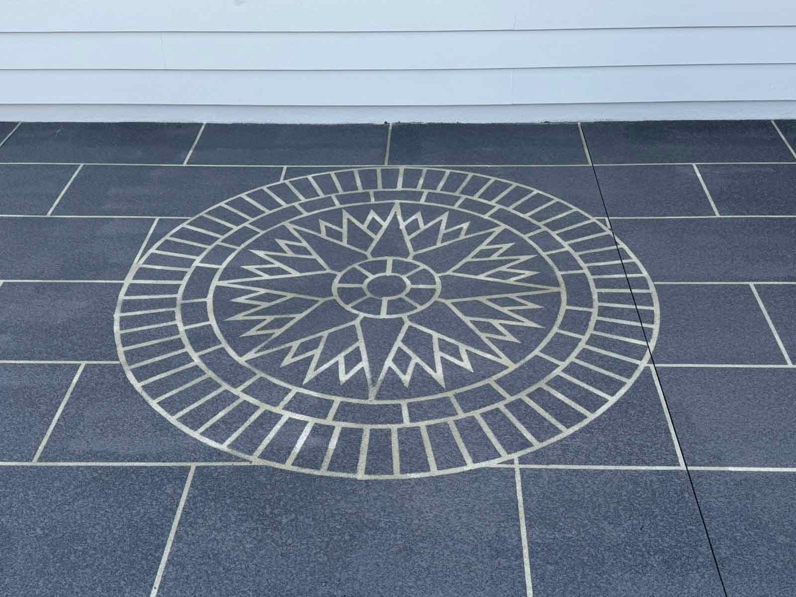 A Black Tile Floor With A Circular Design On It — Custom Concrete Finishes In Thurgoona, NSW