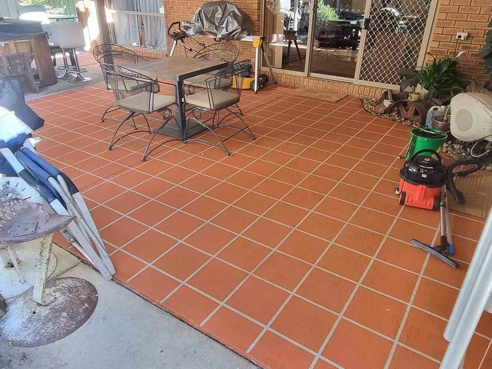 A Patio With A Table And Chairs And A Vacuum Cleaner — Custom Concrete Finishes In Thurgoona, NSW