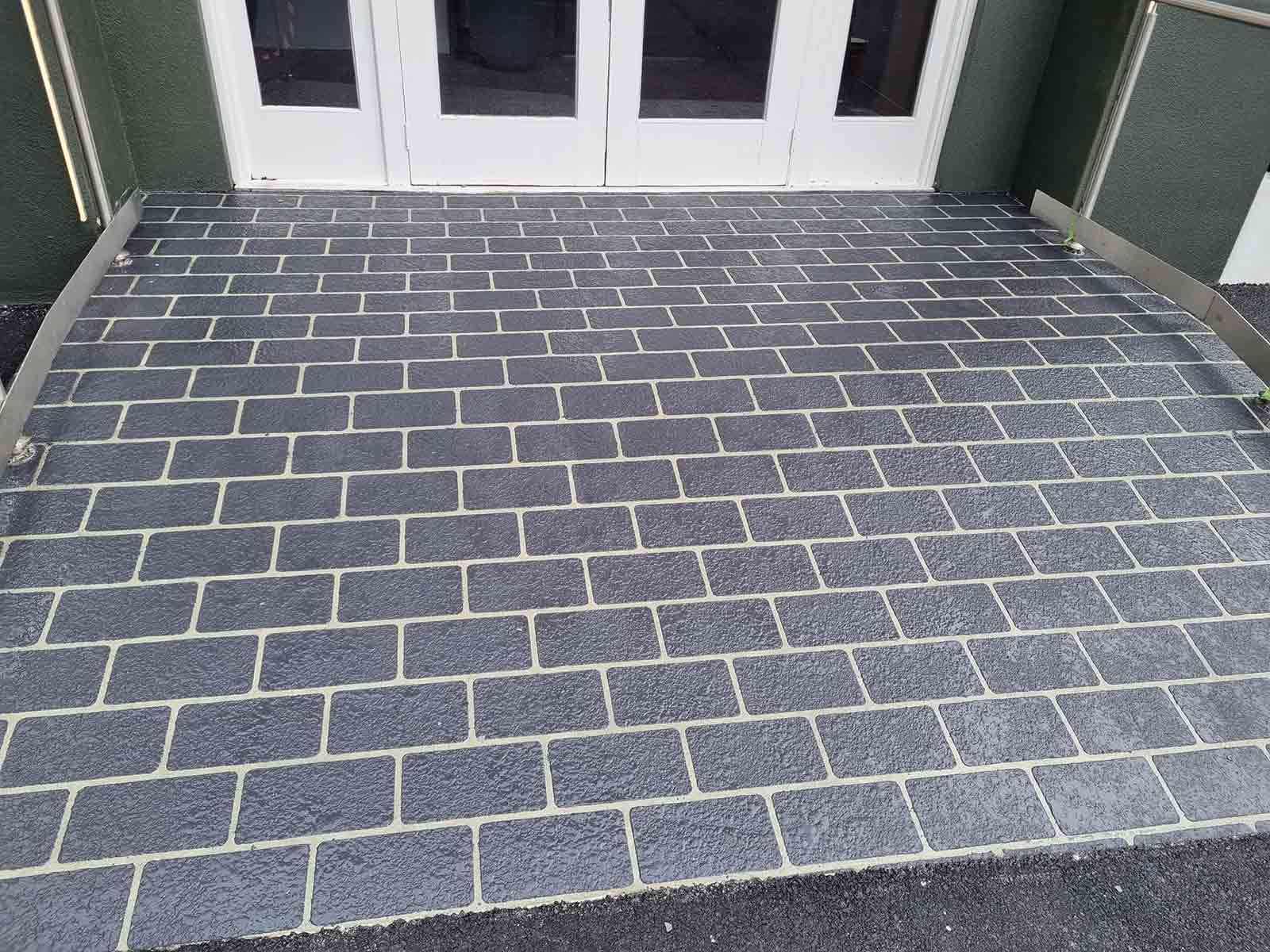 A Brick Walkway With A White Door In The Background — Custom Concrete Finishes In Thurgoona, NSW