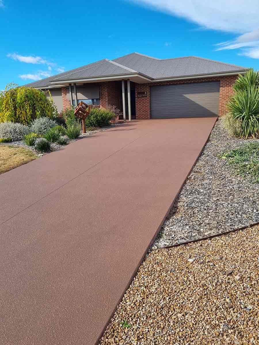 A Driveway Leading To A Large House With A Garage — Custom Concrete Finishes In Thurgoona, NSW