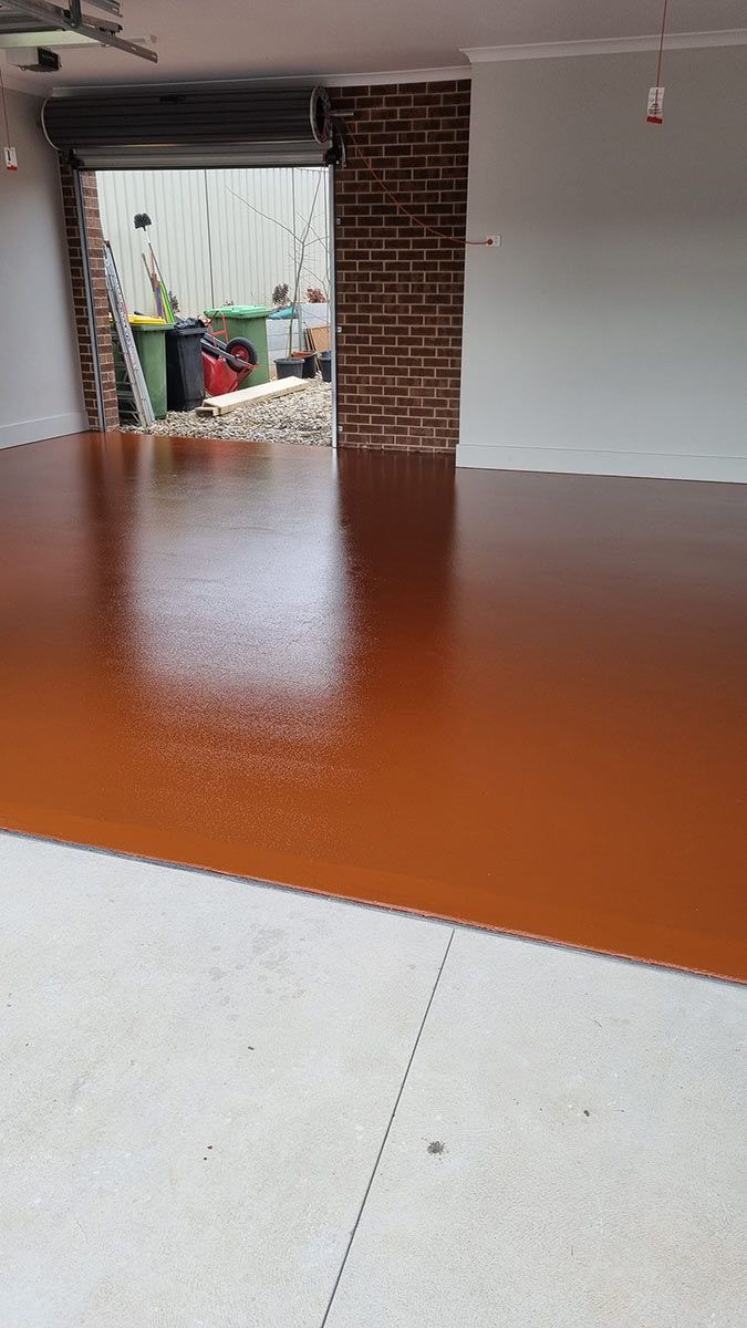 A Garage With A Brown Floor And A Brick Wall — Custom Concrete Finishes In Thurgoona, NSW