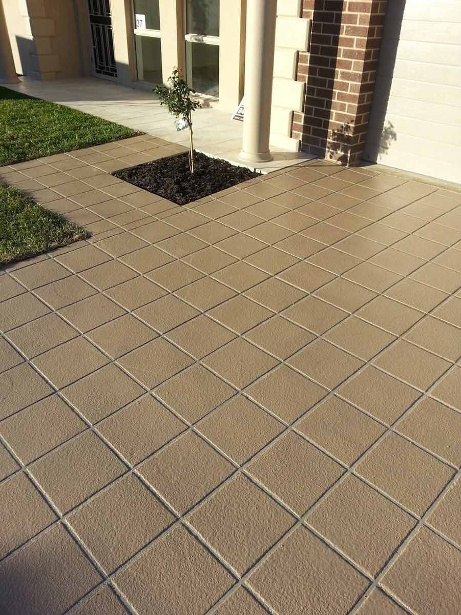 A Brick Walkway With A Tree In The Middle Of It In Front Of A House — Custom Concrete Finishes In Albury, NSW