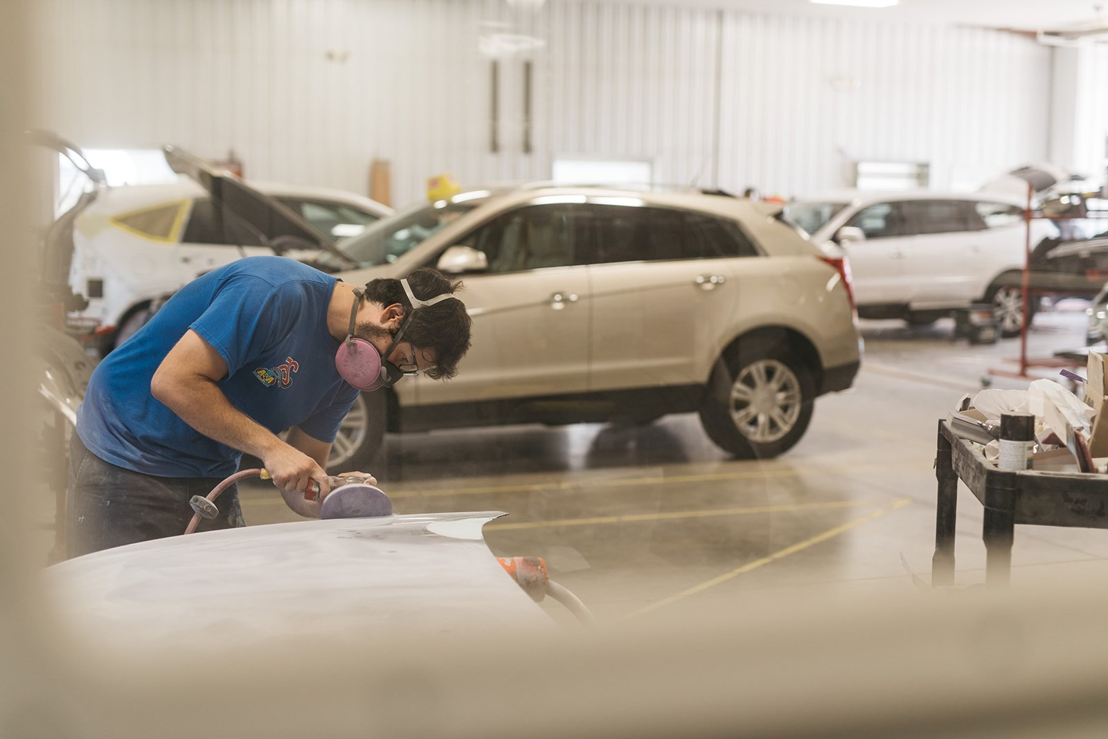 A man is working on a car in a garage.