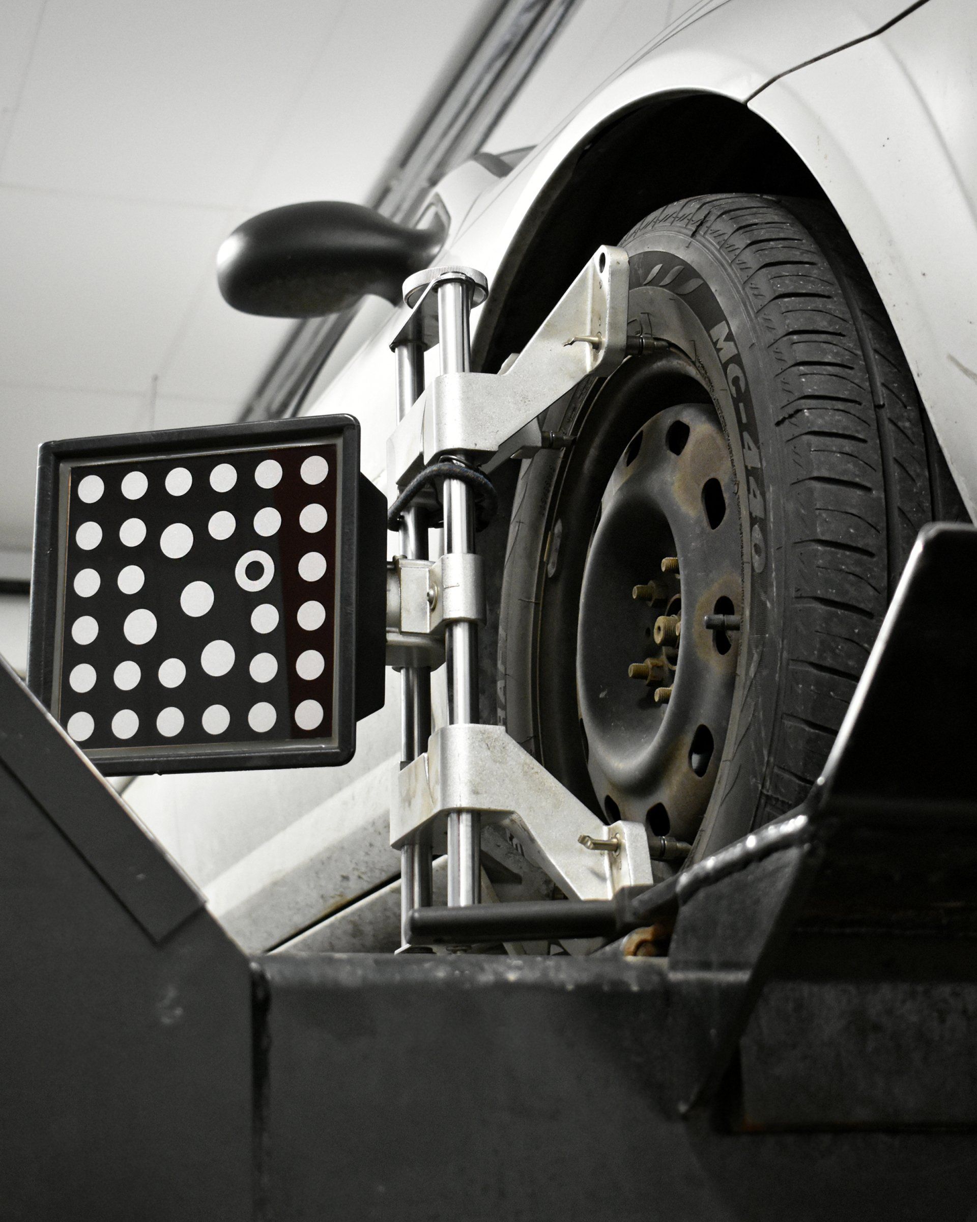 A car is being adjusted by a machine with a circle on it