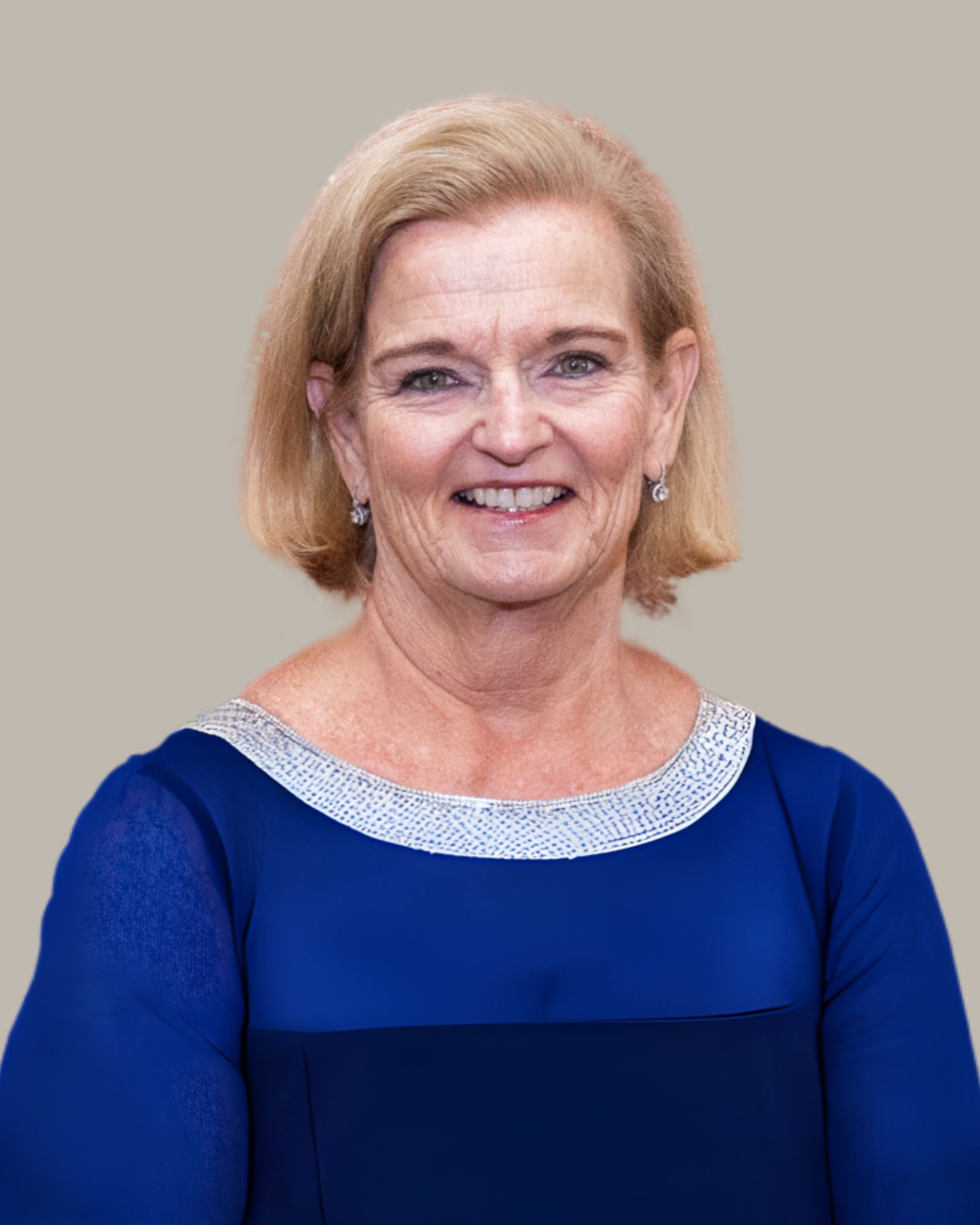 A woman in a blue dress is smiling for the camera.