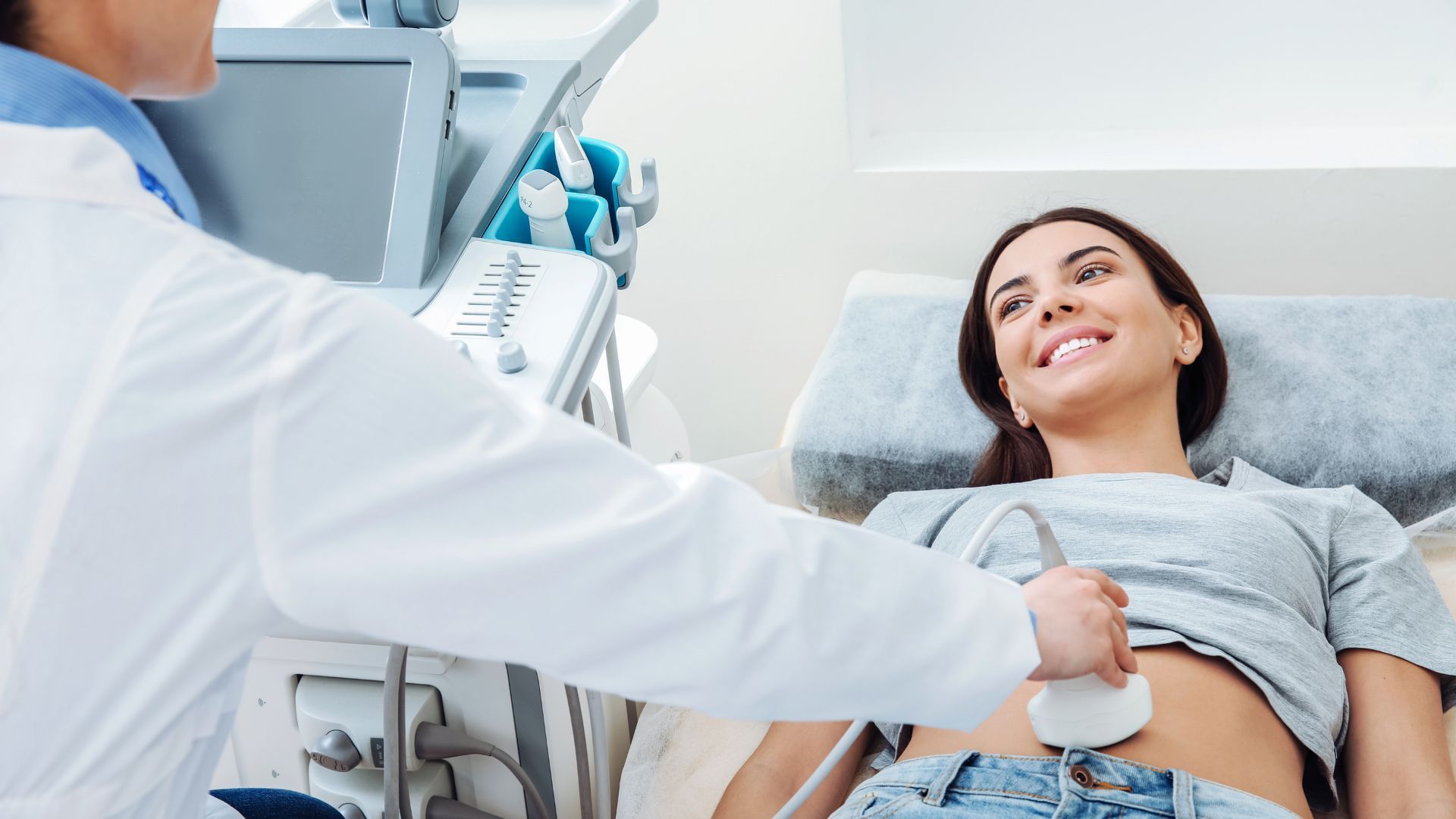 A woman is getting an ultrasound from a doctor.