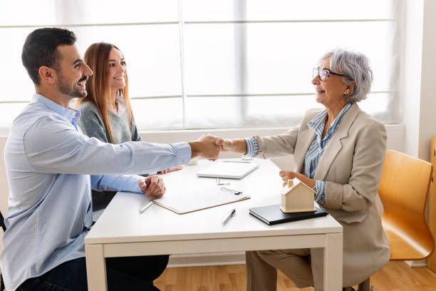 Professional agent from business insurance agency finalizing contract with satisfied clients.