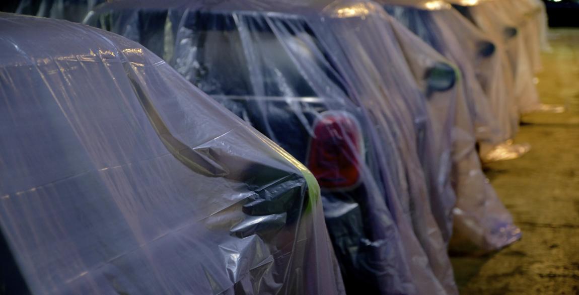 Une photo de l'un des parkings sécurisés de Care4fleets avec des voitures déjà nettoyées et couvertes.