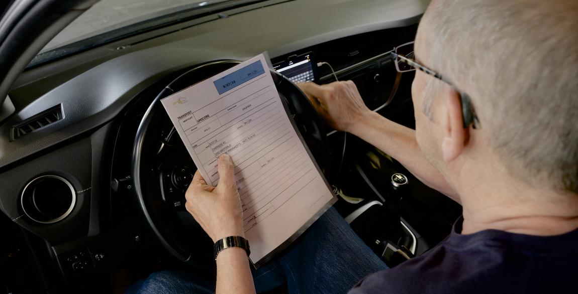 Le chauffeur Care4fleets complète la check-list avant de partir pour le client en voiture.