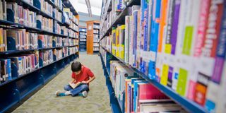 BOY READING in library
