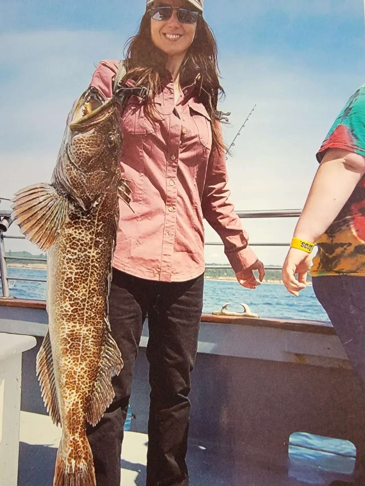 Woman on Boat is Holding a Large Fish