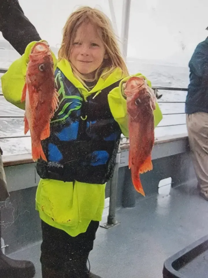 Little Girl is Holding Two Fish
