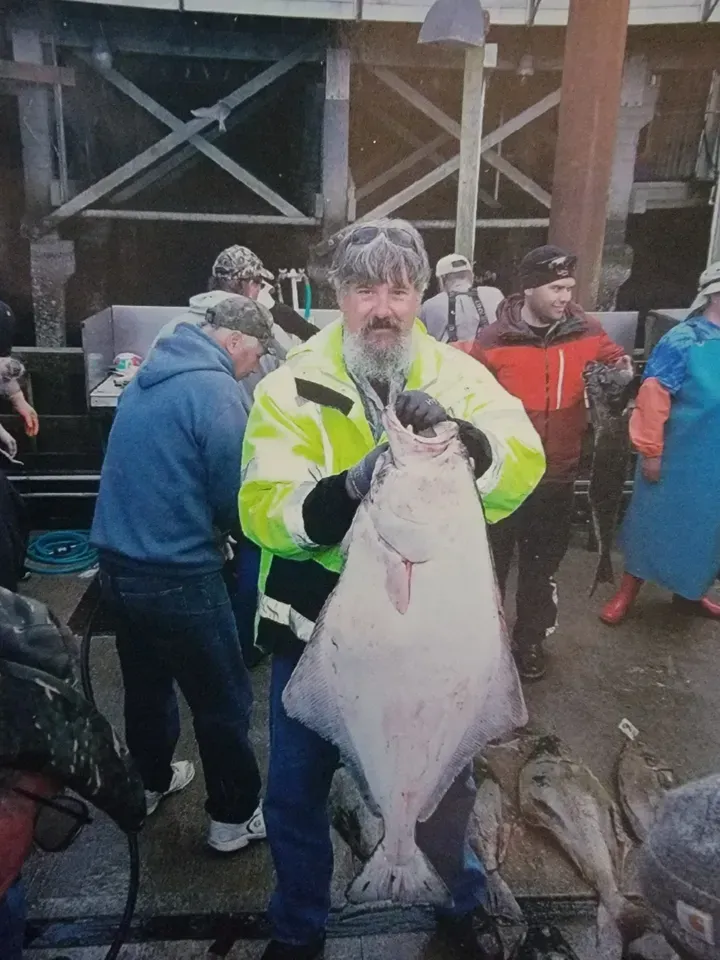 A Man is Holding a Large Fish