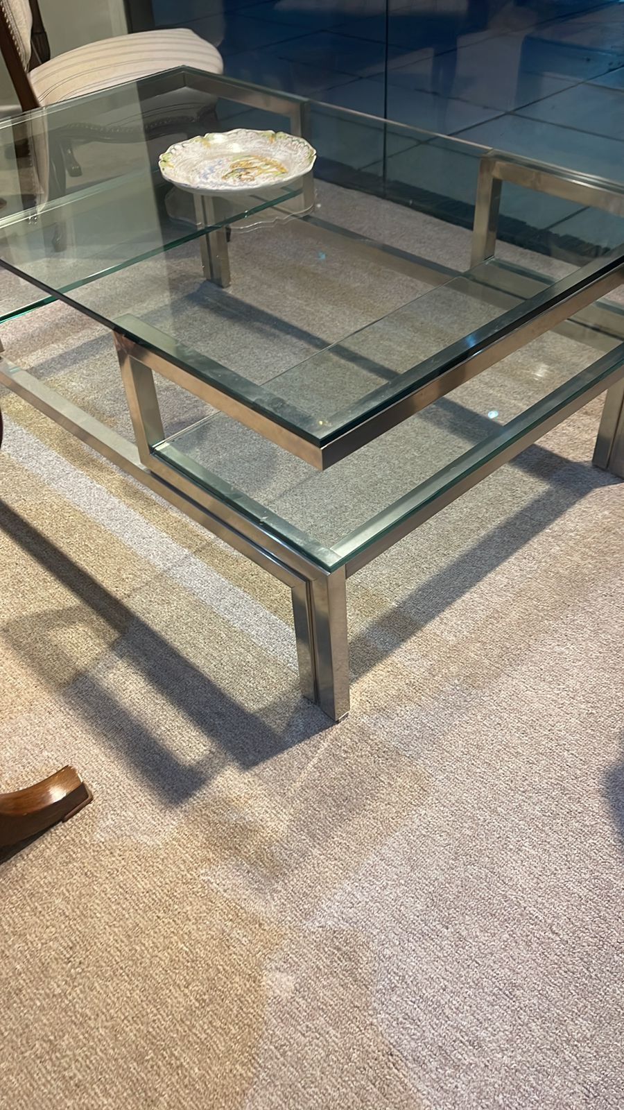 Una mesa de café de cristal con un plato encima.