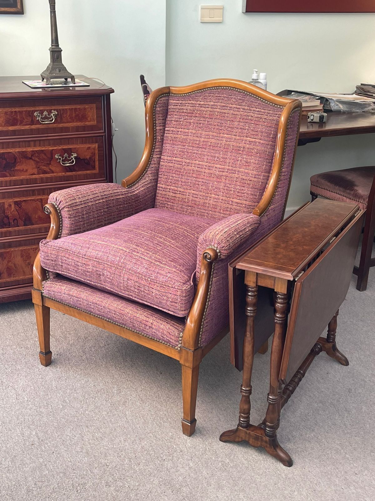 Una silla morada está junto a una mesa de madera en una habitación.