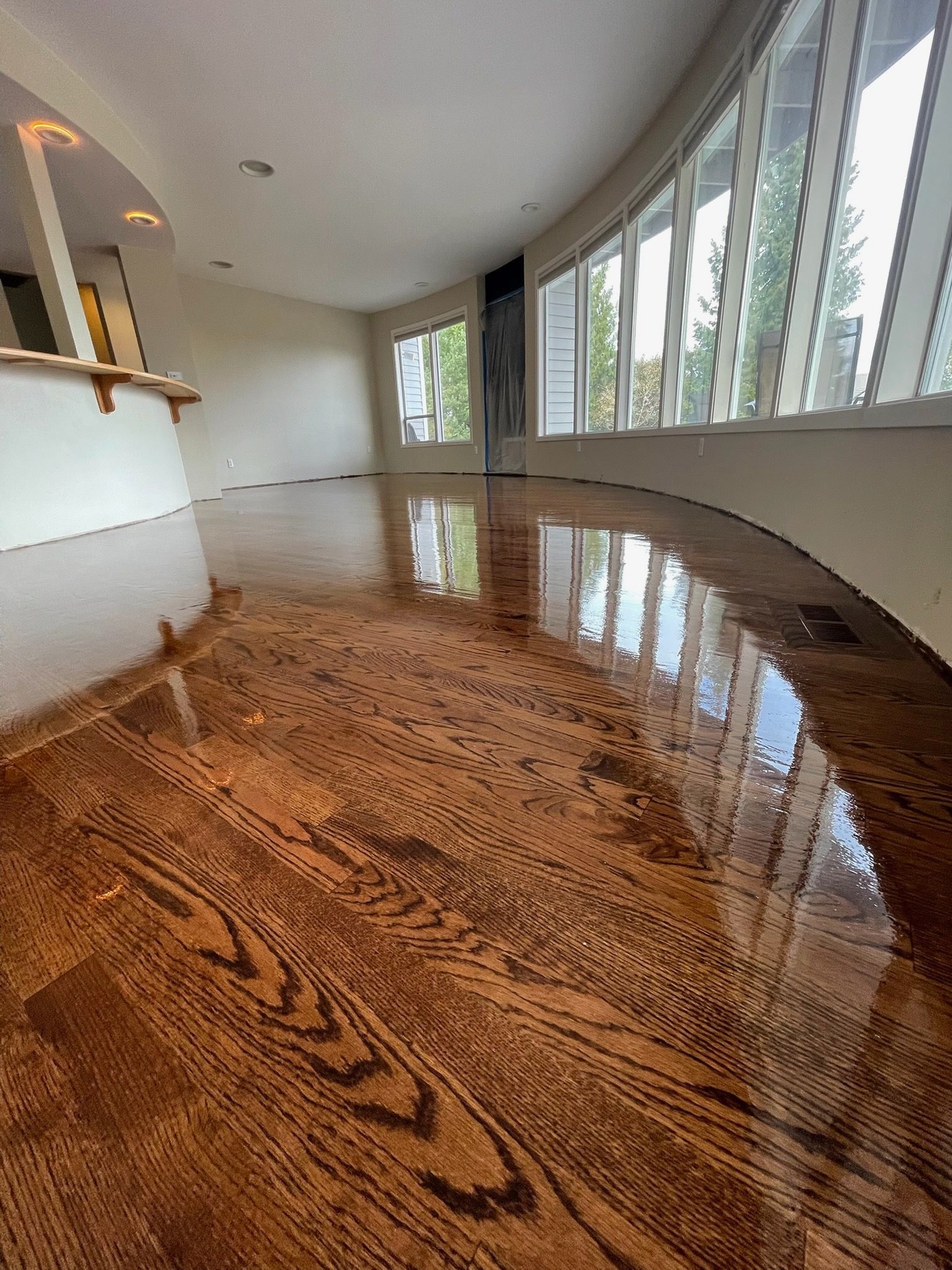 A person with a messy bun and bangs wears a green satin top and holds a straw hat against a bright, sunny sky.