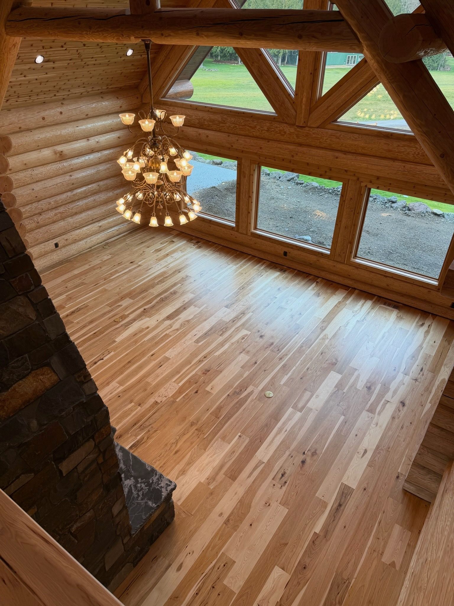 A person with freckles and a bun hairstyle wears a green satin top, holding a large straw hat in golden sunlight.