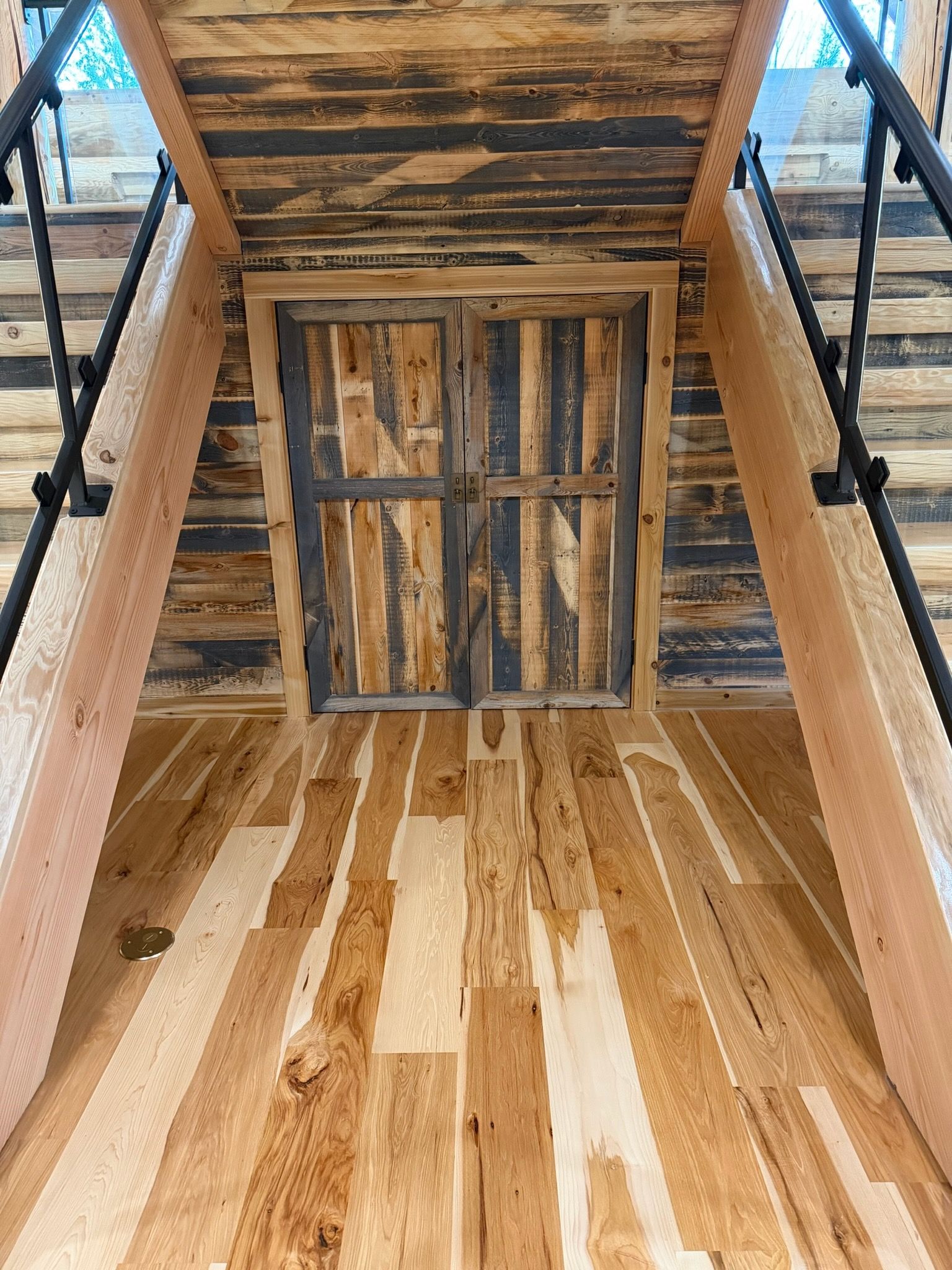 A person with a messy bun and bangs wears a green satin halter top, holding a large straw hat in golden sunlight.