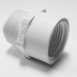 A white plastic pipe connector is sitting on a white surface.