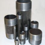 A bunch of metal pipes are stacked on top of each other on a table.