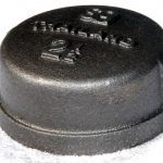 A close up of a metal cap on a white surface.