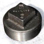 A close up of a metal object on a white surface.