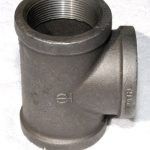 A close up of a metal pipe fitting on a white surface.