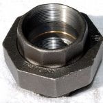 A close up of a metal nut on a white surface.