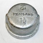 A close up of a metal cap on a white surface.