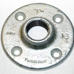 A close up of a metal flange on a white surface.