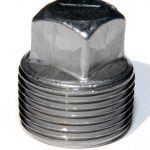 A close up of a stainless steel plug on a white surface.