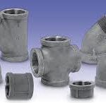 A group of stainless steel pipe fittings are sitting on a table.