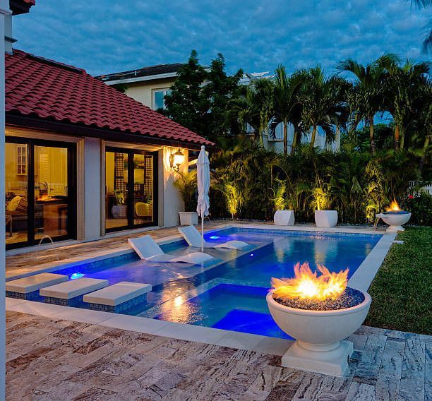 A large swimming pool with a fire pit in the middle