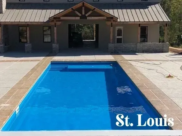 A large swimming pool in front of a house.