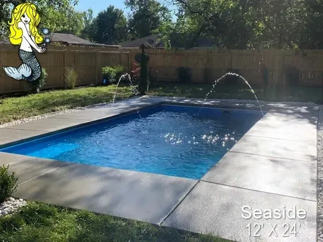 A small swimming pool with a fountain in the backyard.
