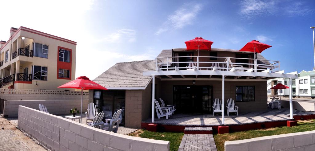 A house with umbrellas and chairs in front of it
