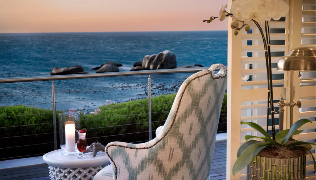 A chair is sitting on a balcony overlooking the ocean.