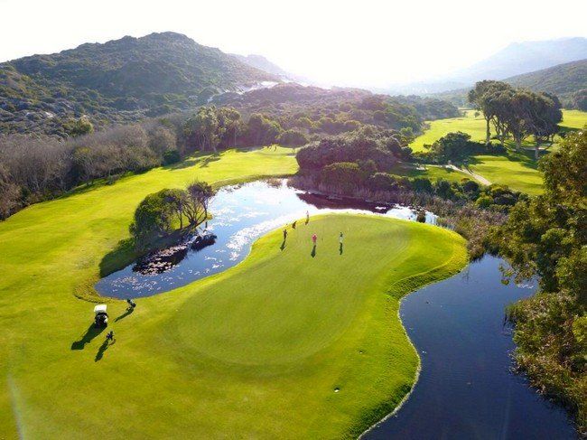 An aerial view of a golf course with a lake in the middle
