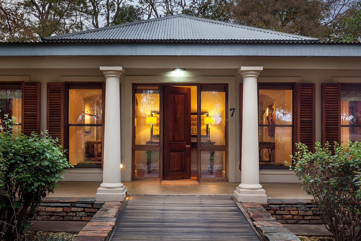 The front of a house with a wooden walkway leading to it.