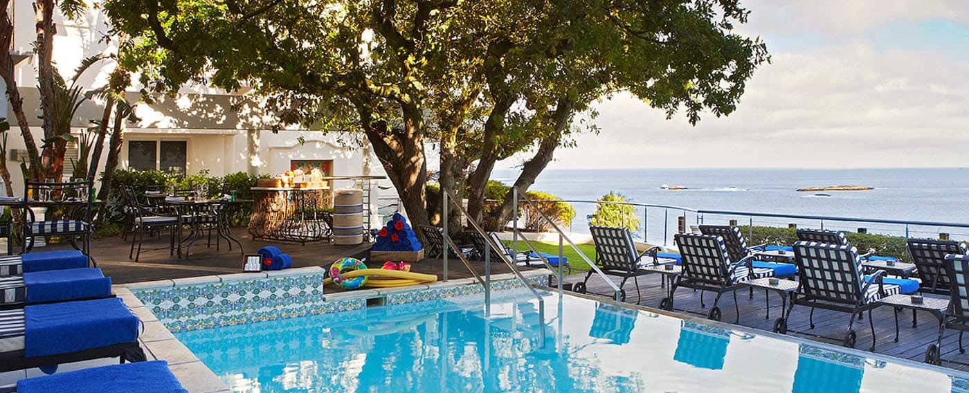 There is a large swimming pool with a view of the ocean.