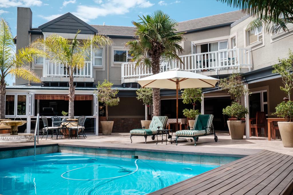 A large house with a swimming pool in front of it.
