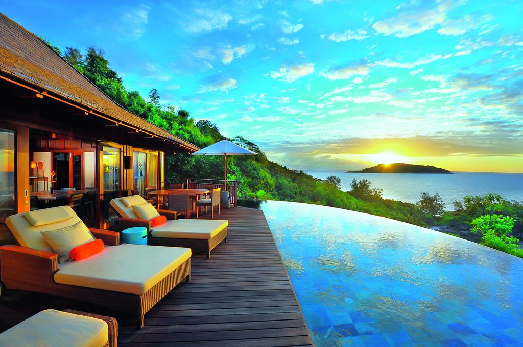 There is a swimming pool with a view of the ocean.