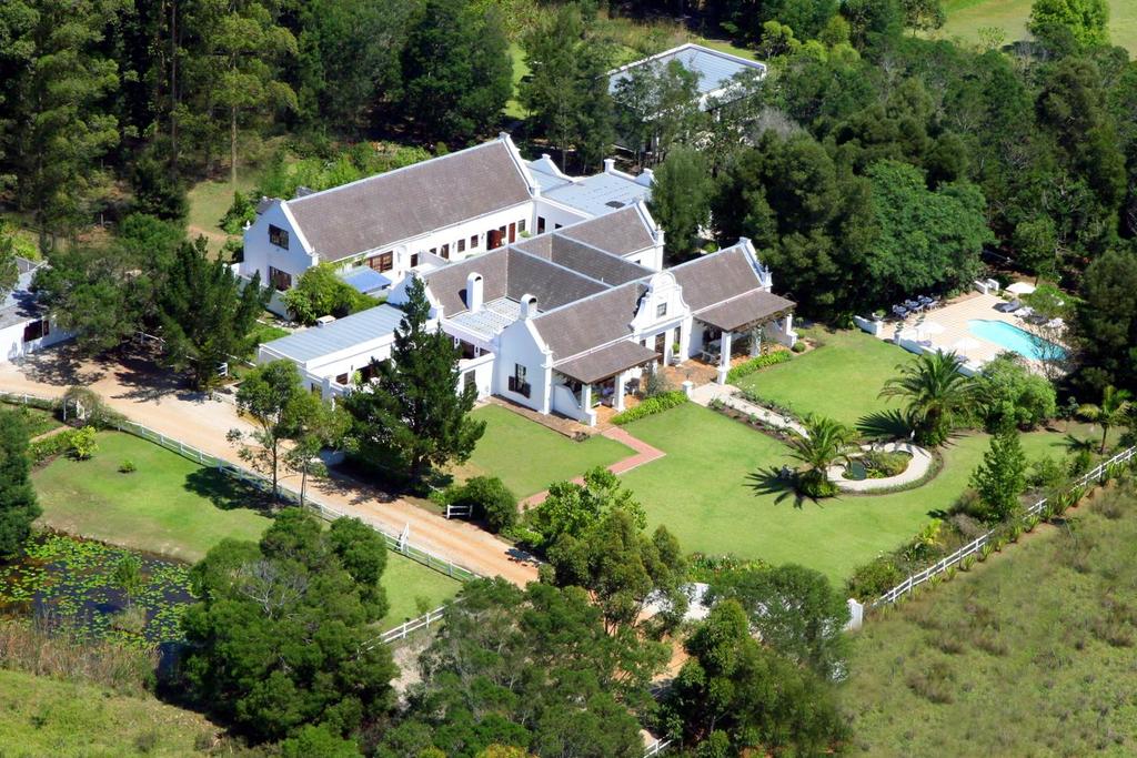 An aerial view of a large white house surrounded by trees