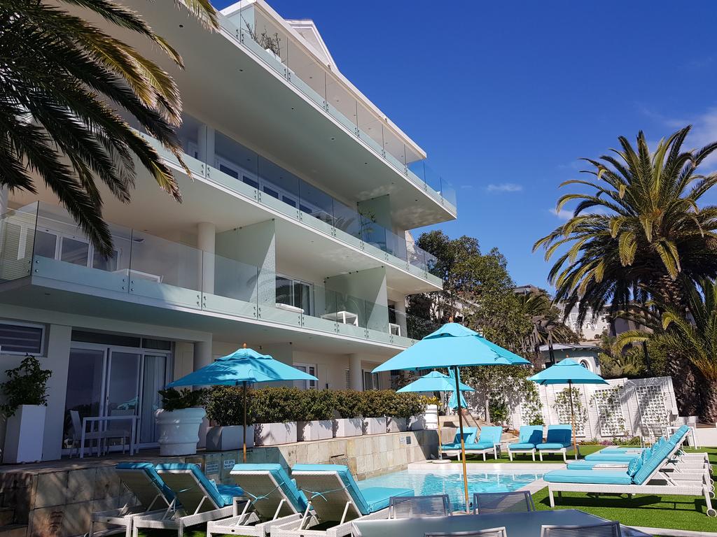A large building with a pool and umbrellas in front of it