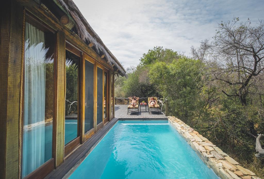 There is a large swimming pool in front of a house.