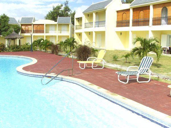 A swimming pool with chairs around it and buildings in the background