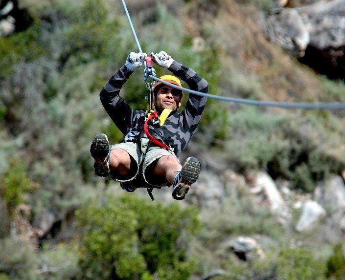 A man is flying through the air on a zip line