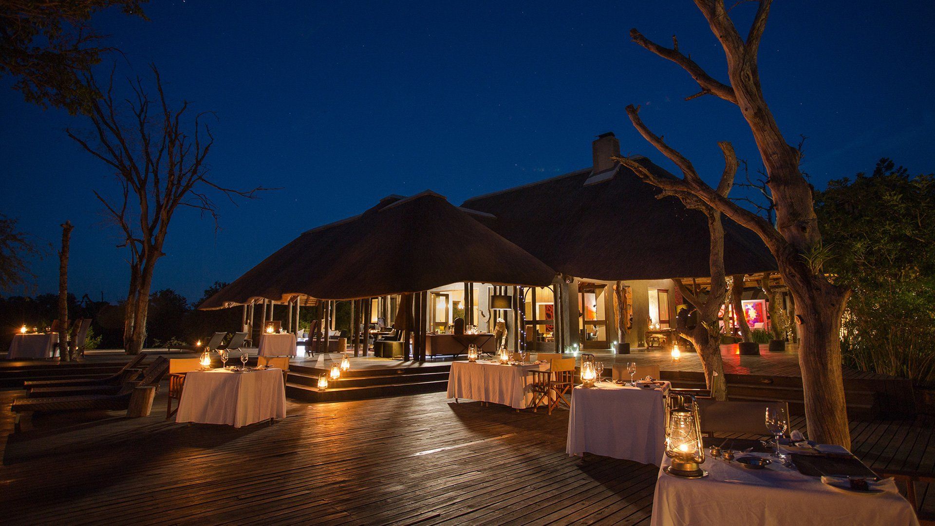 A large building with tables set up in front of it at night.