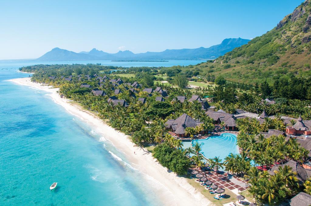 An aerial view of a tropical beach with palm trees and a swimming pool.