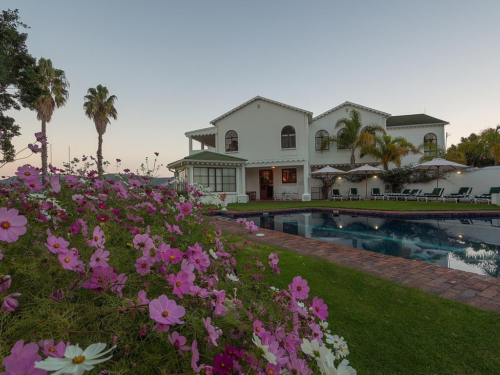 A large white house with a swimming pool in front of it